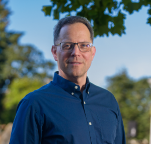 John Durno in a blue shirt, looking professional